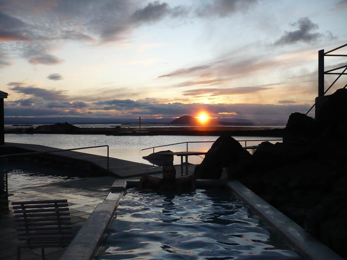 Lugares para bañarse en Islandia. Una terma islandesa con una puesta de sol al fondo.